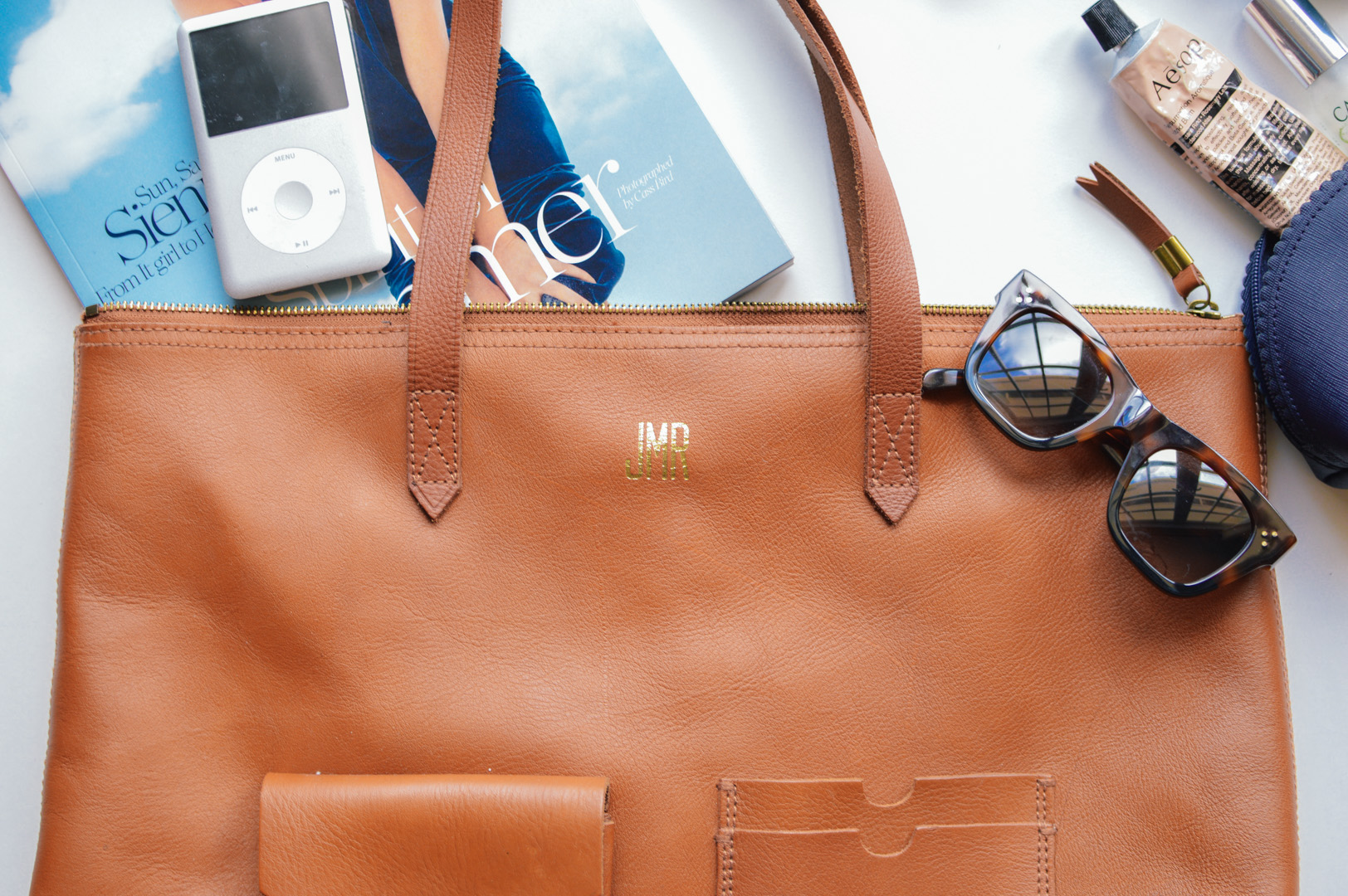 Travel essentials in a Madewell Leather Tote 