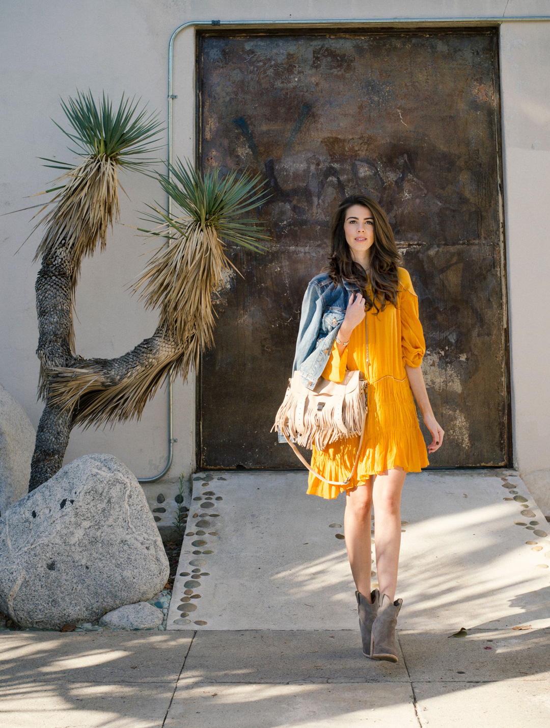 Jackie Roque styling a Zara yellow dress, Proenza Schouler Bag, and Joie boots