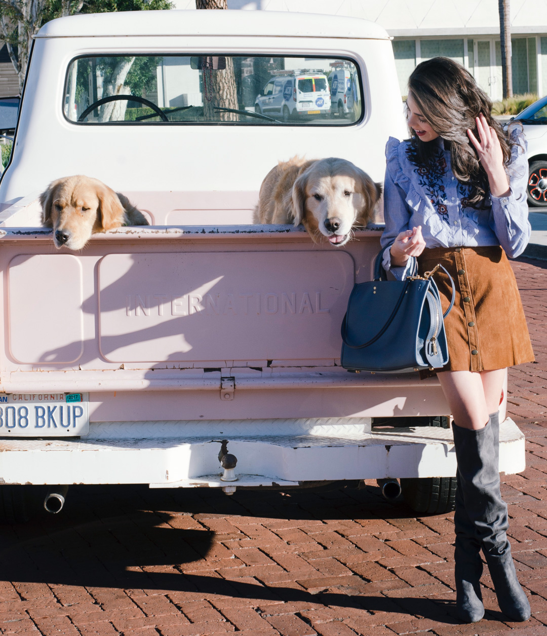 Jackie Roque styling an outfit with puppies and a pink truck in Malibu.