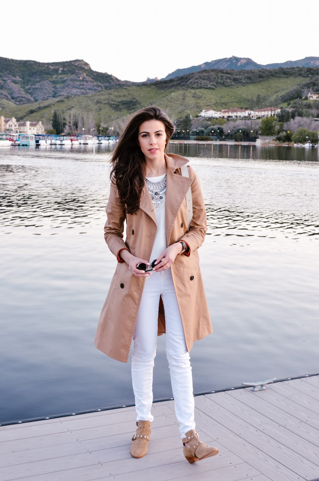Jackie Roque styling a white on white look with J Brand white jeans, Madewell top, trench coat, and Maiyet white bag.