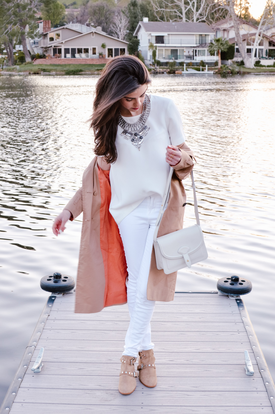 Jackie Roque styling a white on white look with J Brand white jeans, Madewell top, trench coat, and Maiyet white bag. 