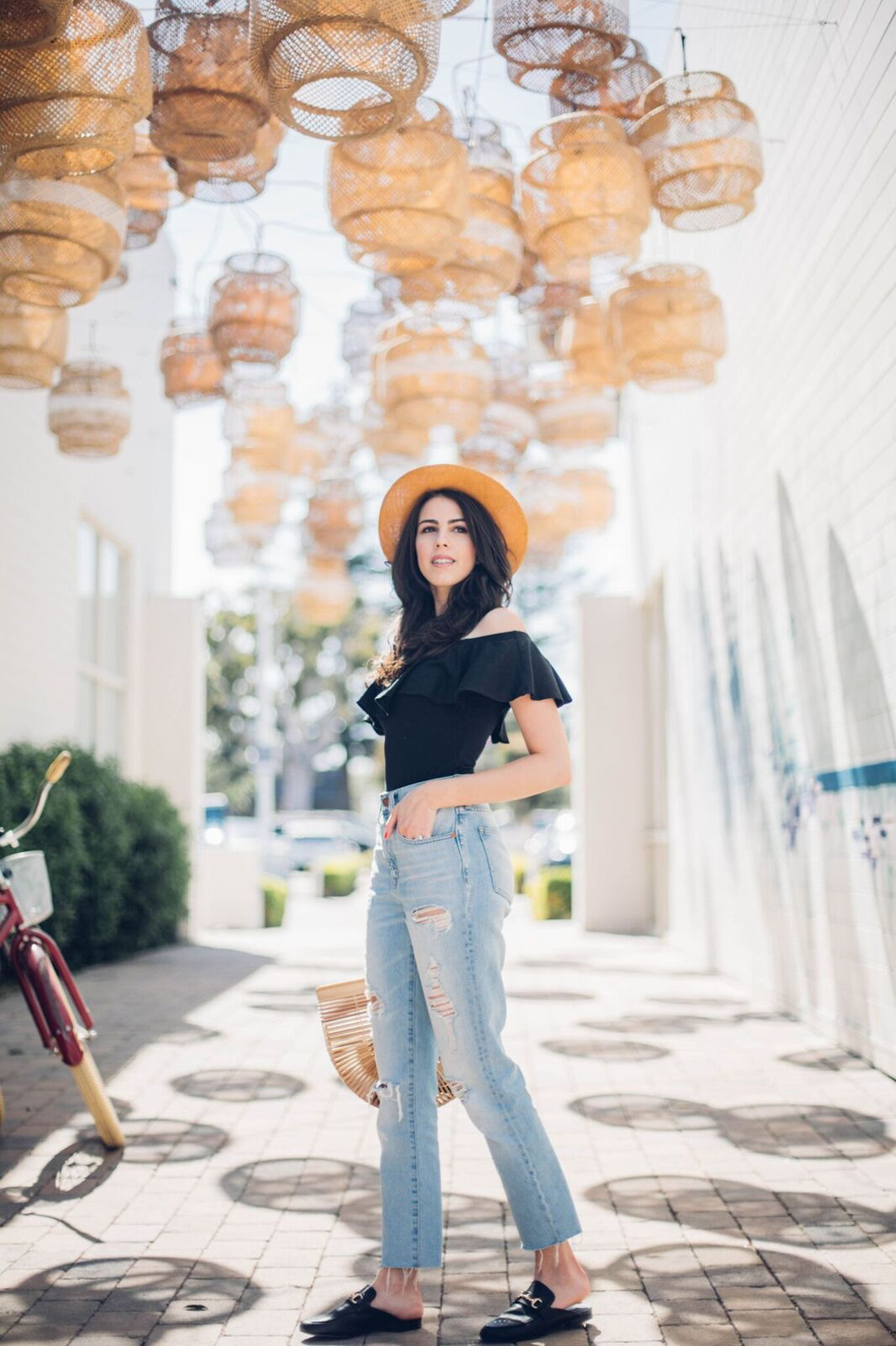 Jackie Roque styling a Aqua off-the-shoulder body suit, Madewell jeans and a Cult Gaia Arc bag.