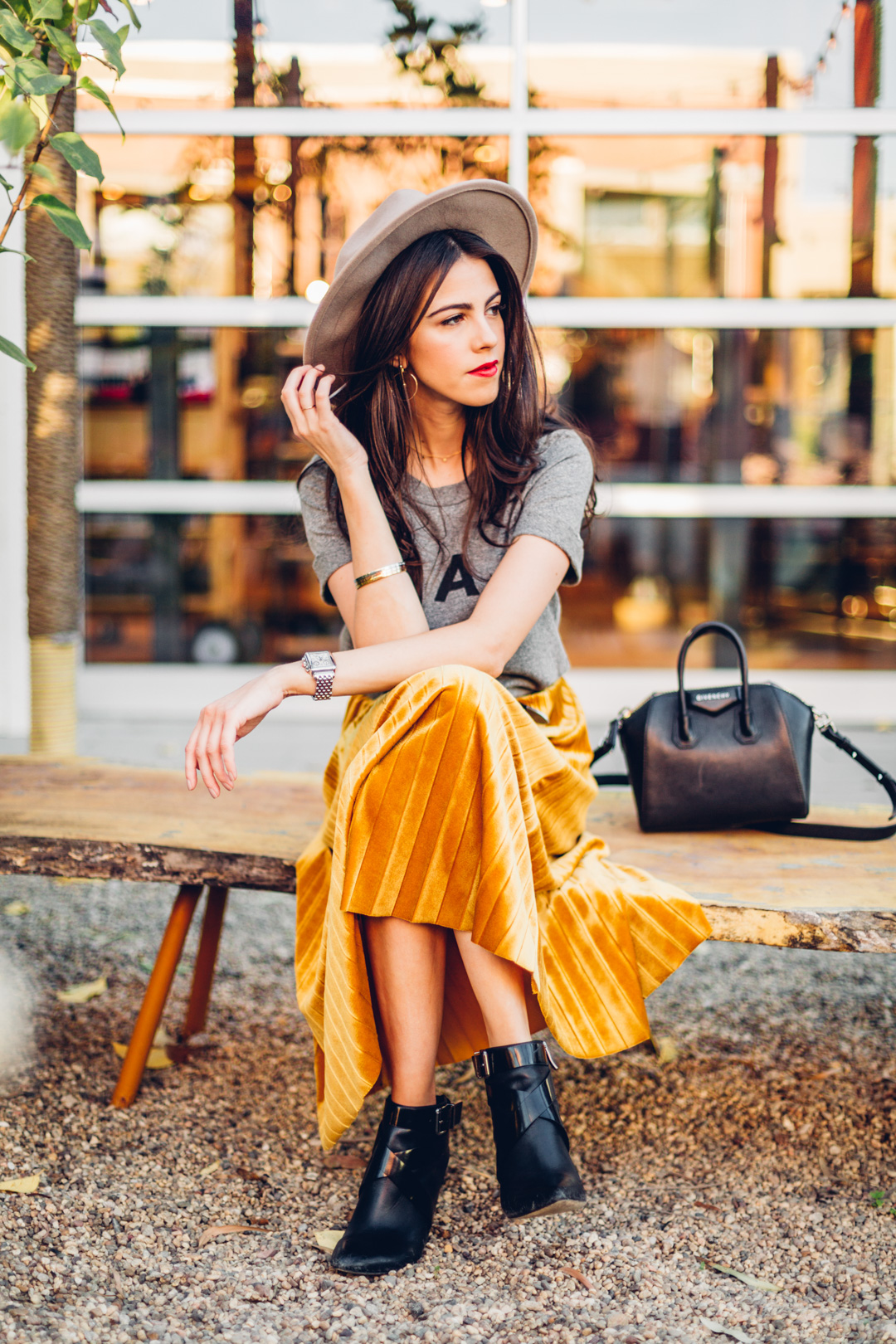 Jackie Roque styling a velvet pleated skirt, Sol Angeles Ciao Tee and a Givenchy Micro Antigona Bag in Malibu.