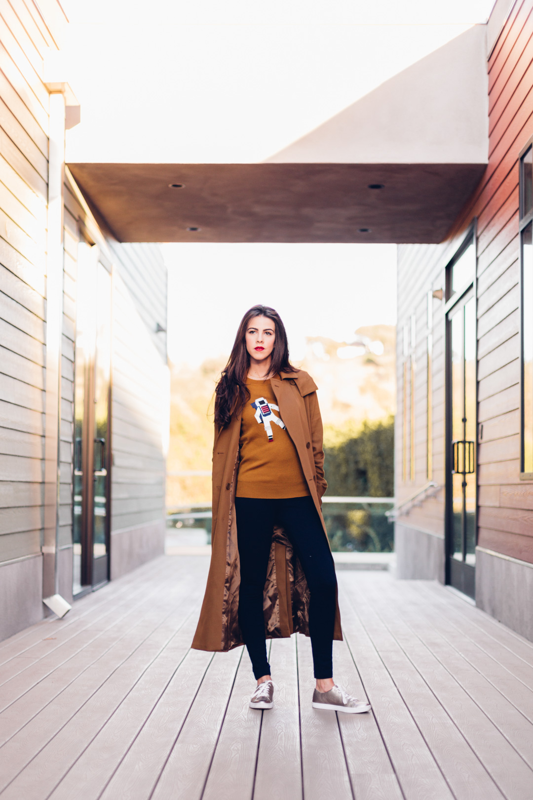 Jackie Roque styling a Lacoste Fall 2017 look with a brown trench coat and astronaut sweater.
