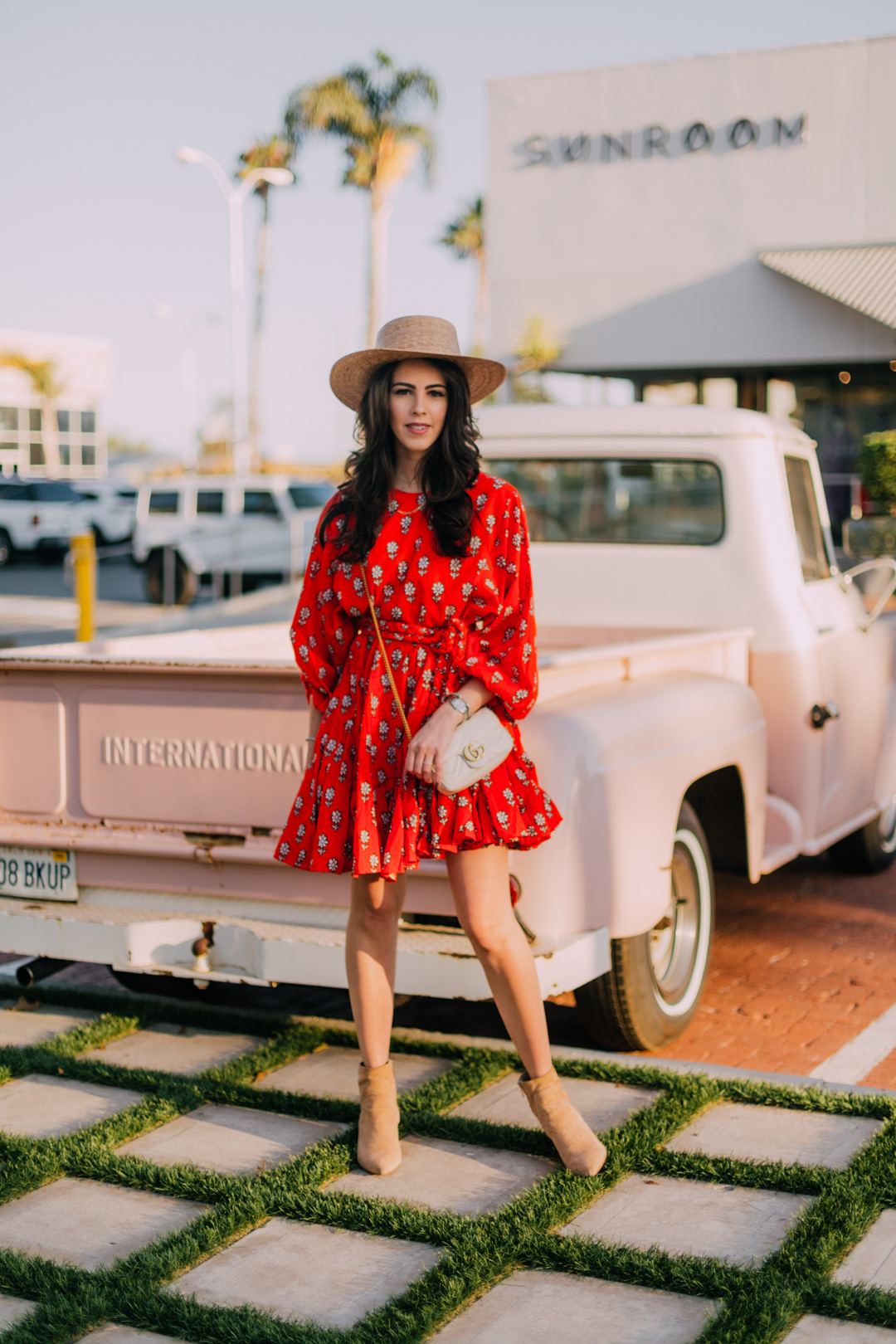 Jackie Roque Salas styling a Rhode Ella Dress, Lack of Color Hat, and Sam Edelman boots in Malibu, california.